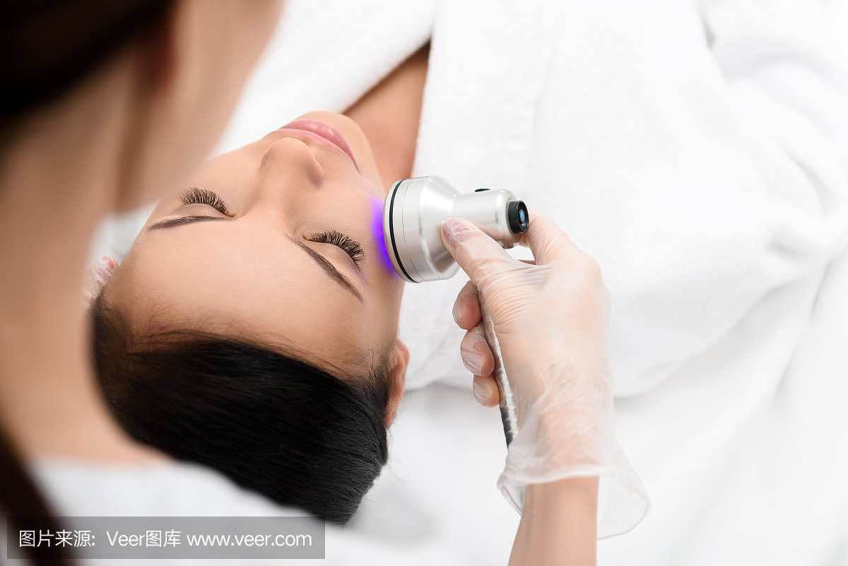 专业美容师利用超声波设备治疗人脸